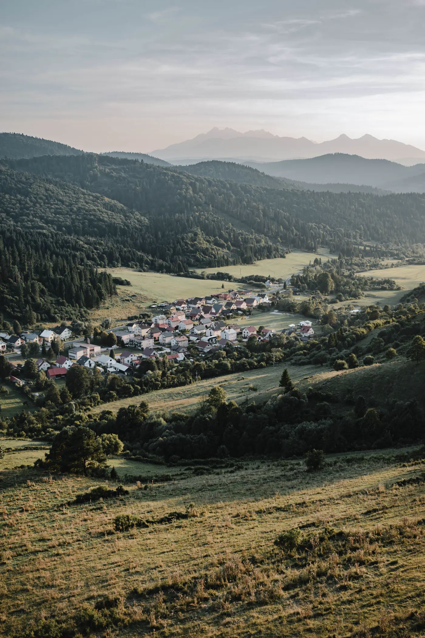 A Slovak village in a valley at sunrise, with the Tatra mountains behind